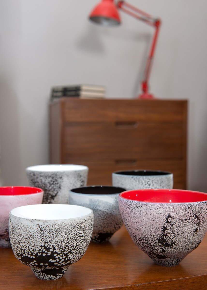 Black white and red glass tea bowls on a table top