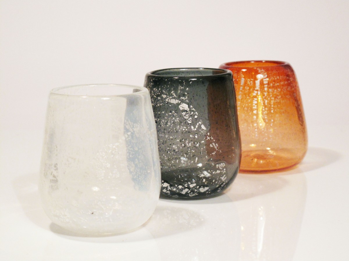 Three glass canlde holders in white, grey and apricot with silver leaf