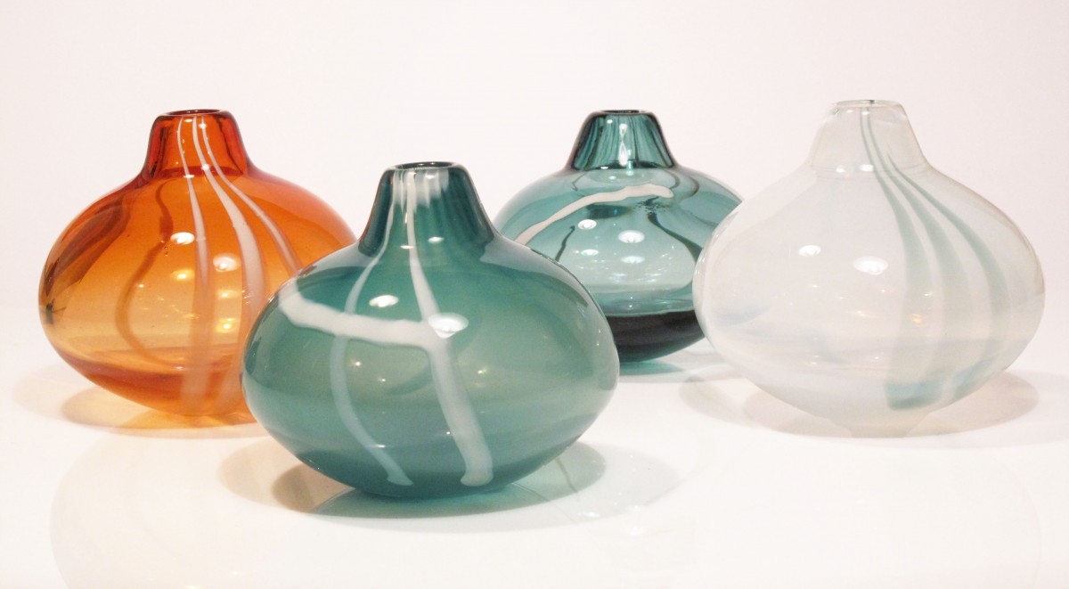 Four small glass vases in apricot,sea green and white